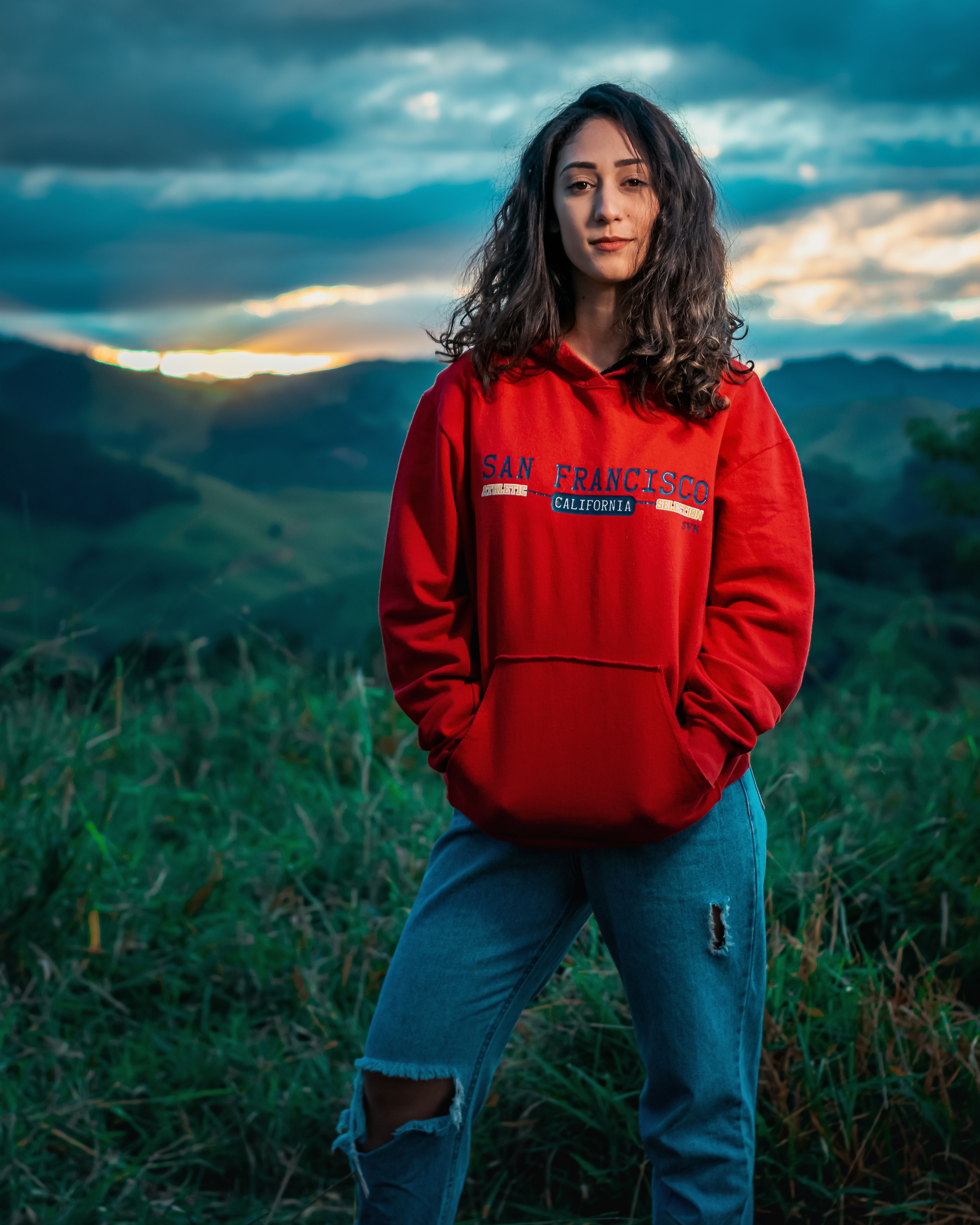Woman in Red Hoodie Standing on Green Grass Field · Free Stock Photo