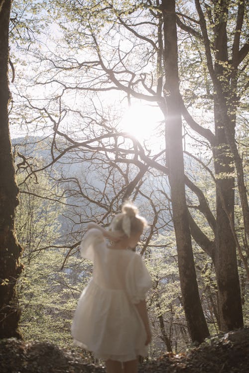 Girl in White Dress Standing in Forest