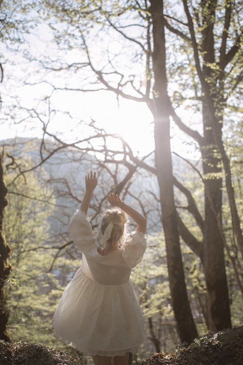 Girl in White Dress Standing on Forest