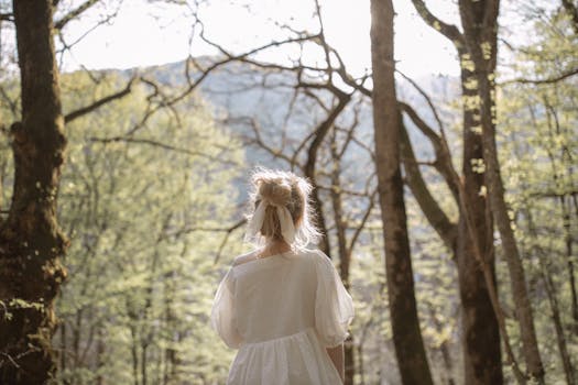 宁静的森林中，一位身穿白色连衣裙的孤独女子独自站立