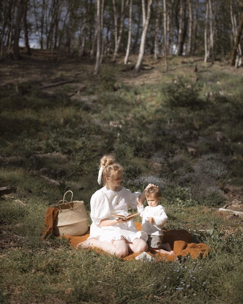 A Woman with a Kid Having Picnic on the Grassland
