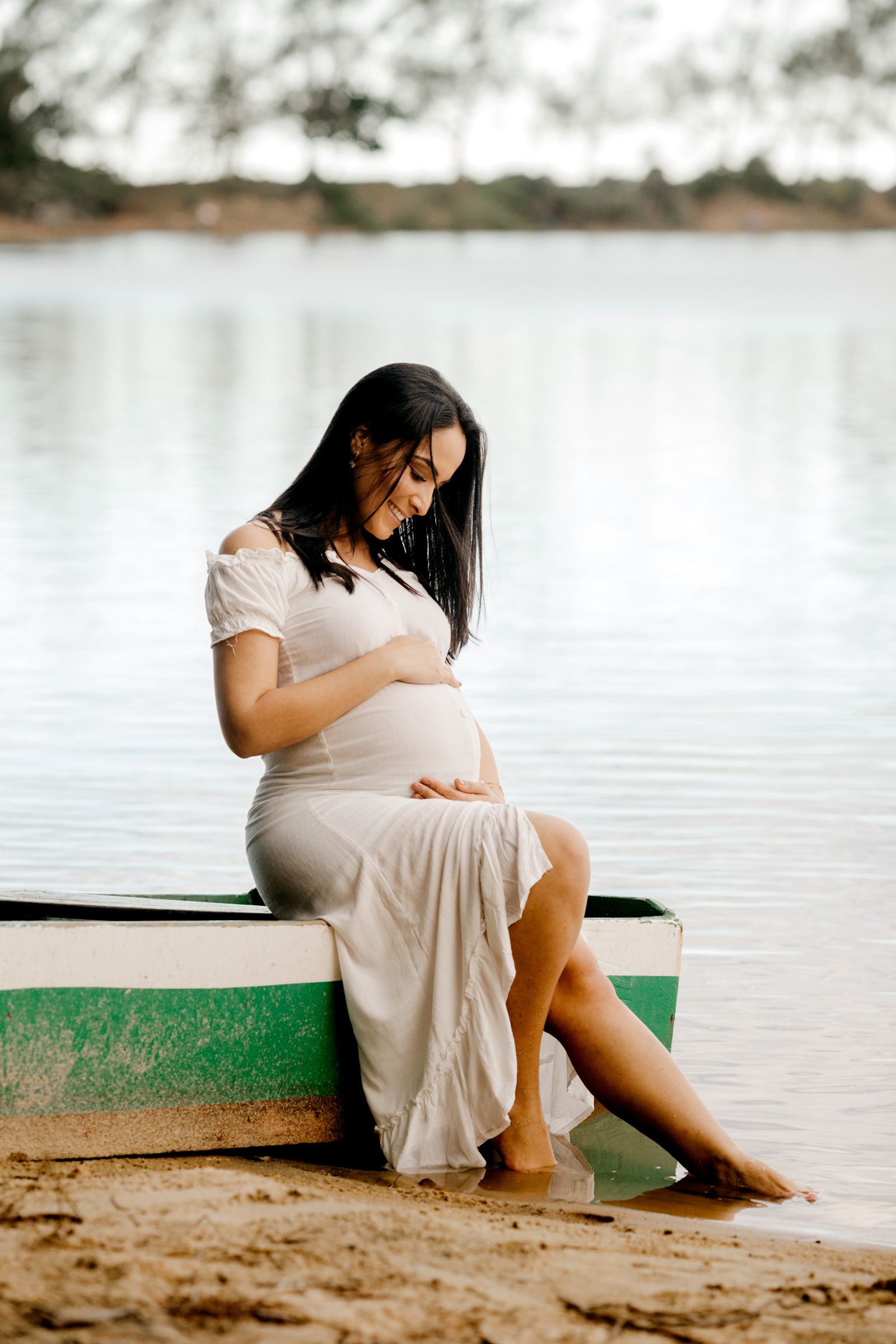 Expectant mother in a flowing white dress outdoors