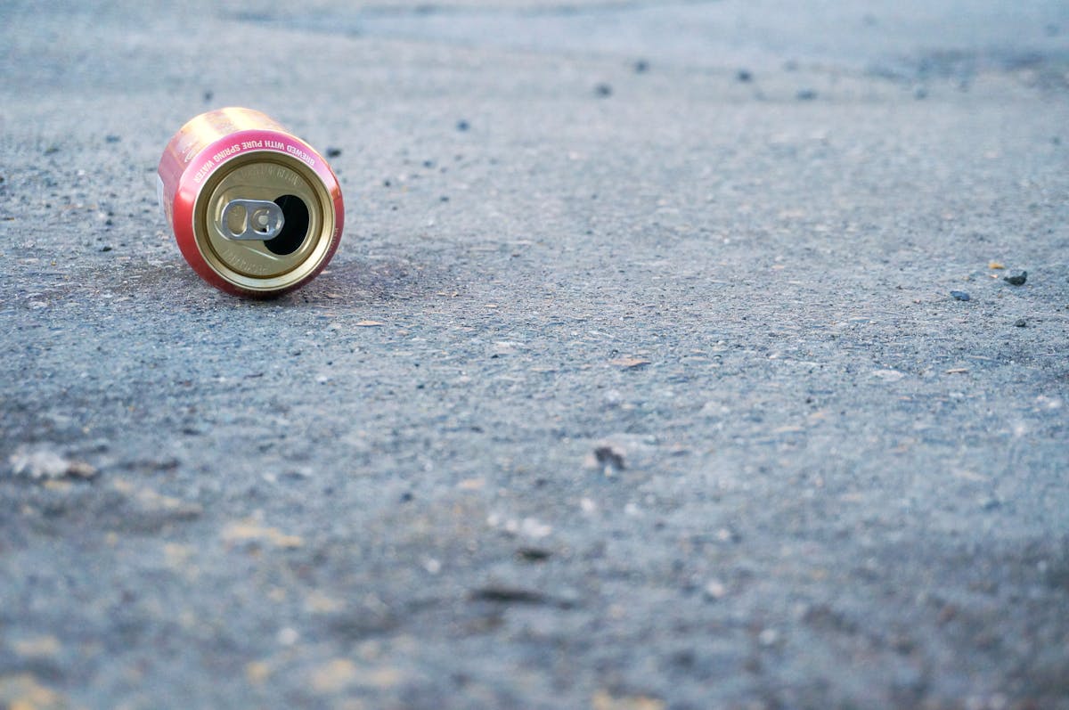 Photo of Empty Soda Can on Concrete Floor