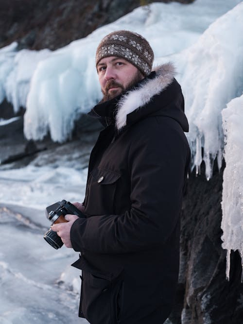 Man in Black Winter Jacket Holding Black Dslr Camera