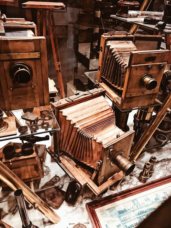 Free From above collection of various wooden vintage photo cameras placed in showcase of antique shop Stock Photo