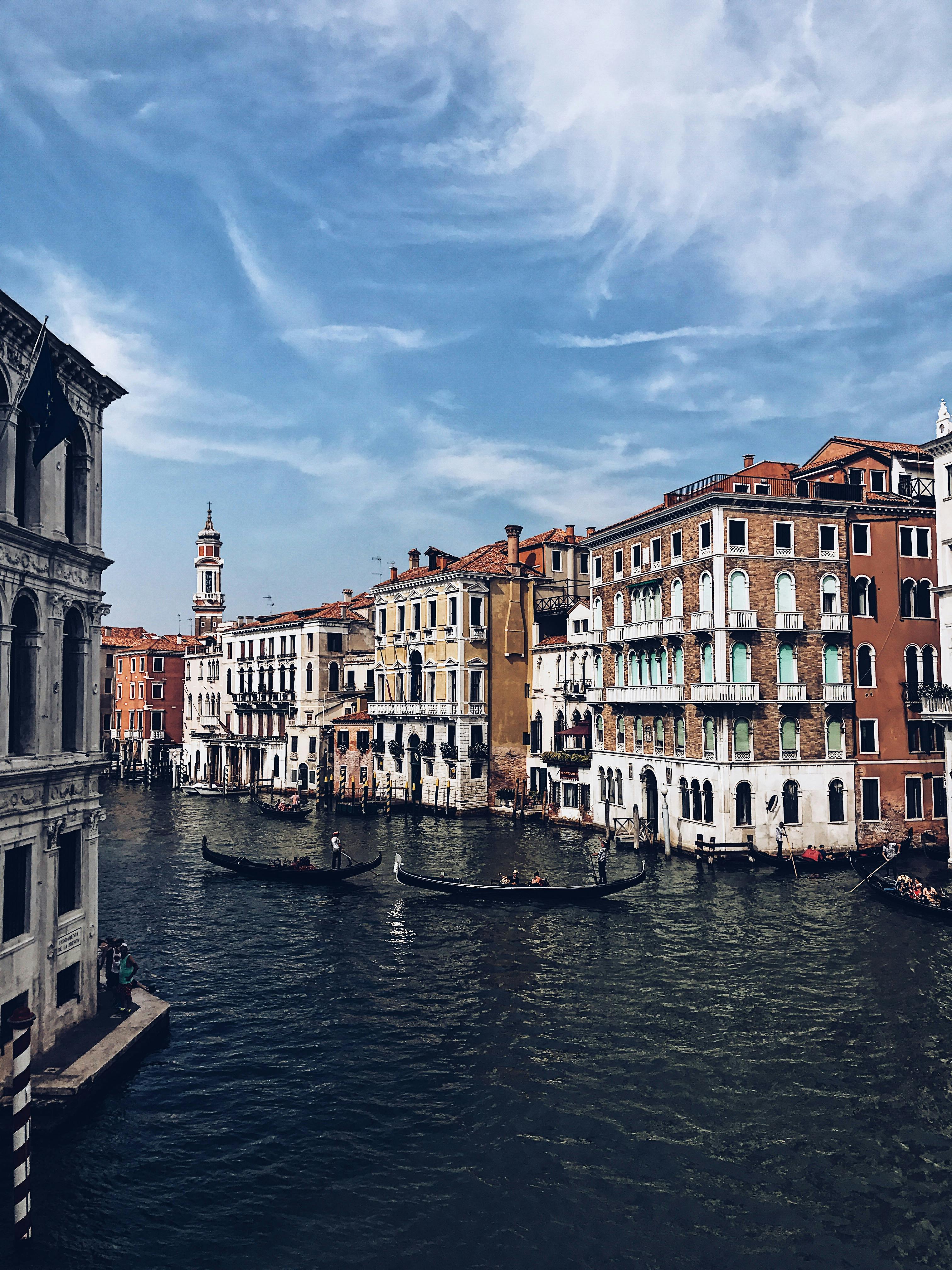 traditional gondolas floating on canal near beautiful old houses