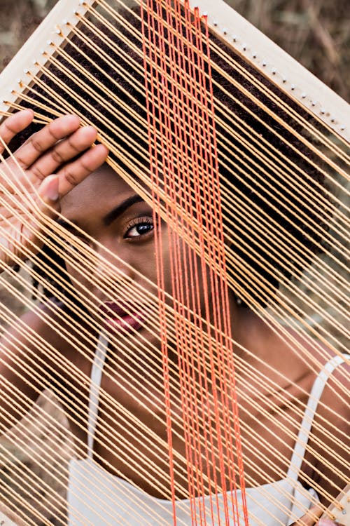 Free Portrait of Woman Looking Through Strings of Instrument Stock Photo
