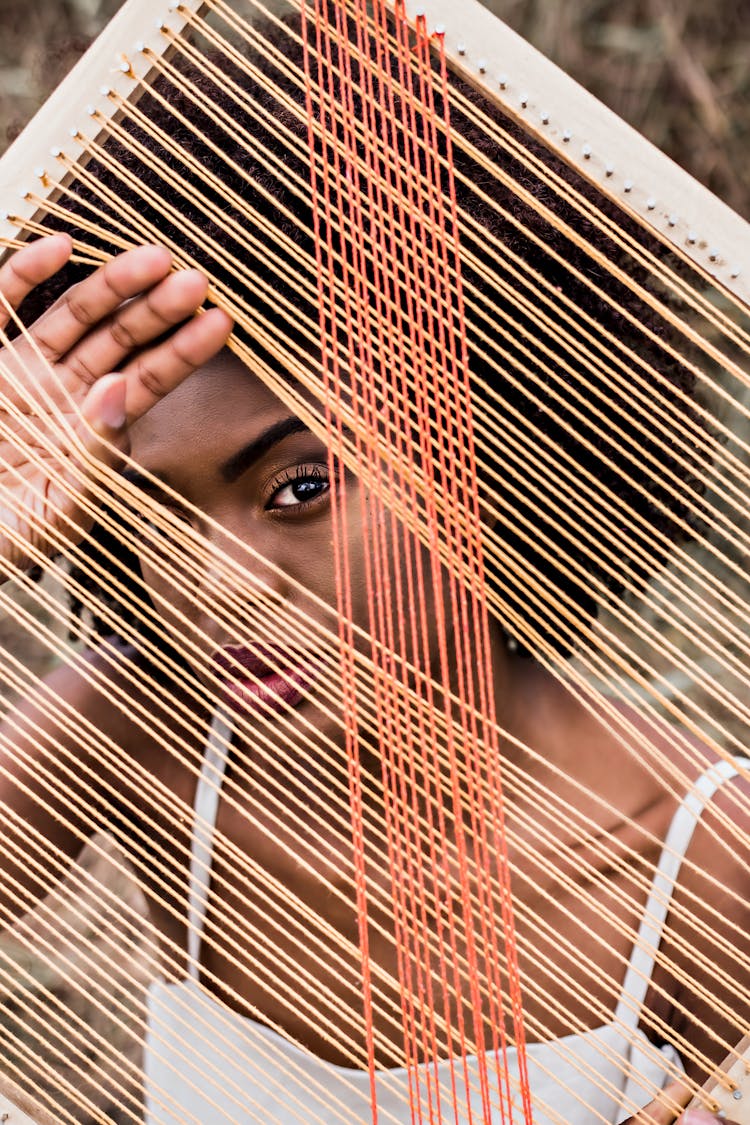 Portrait Of Woman Looking Through Strings Of Instrument