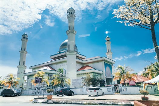 A stunning mosque with tall minarets and a dome on a clear sunny day.