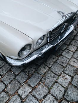 Close-up of a vintage car's details parked on a cobblestone street in Berlin, Germany.