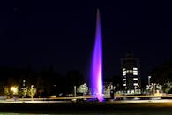 在现代城市景观中，夜间被照亮的喷泉充满活力，令人惊叹