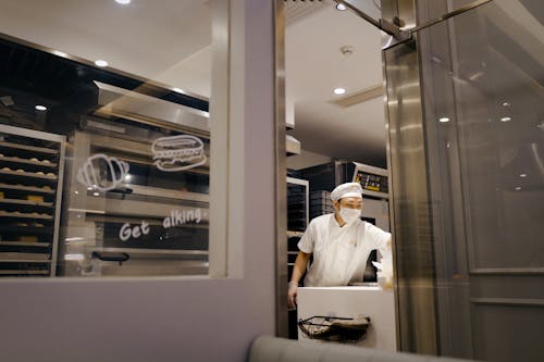Free A Man in White Uniform in the Store Kitchen Stock Photo
