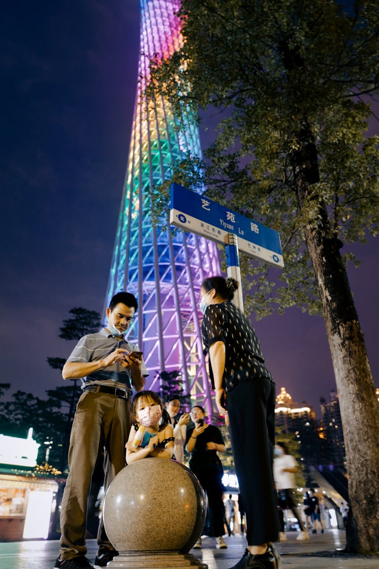 Family Enjoying Walk In Downtown By Night