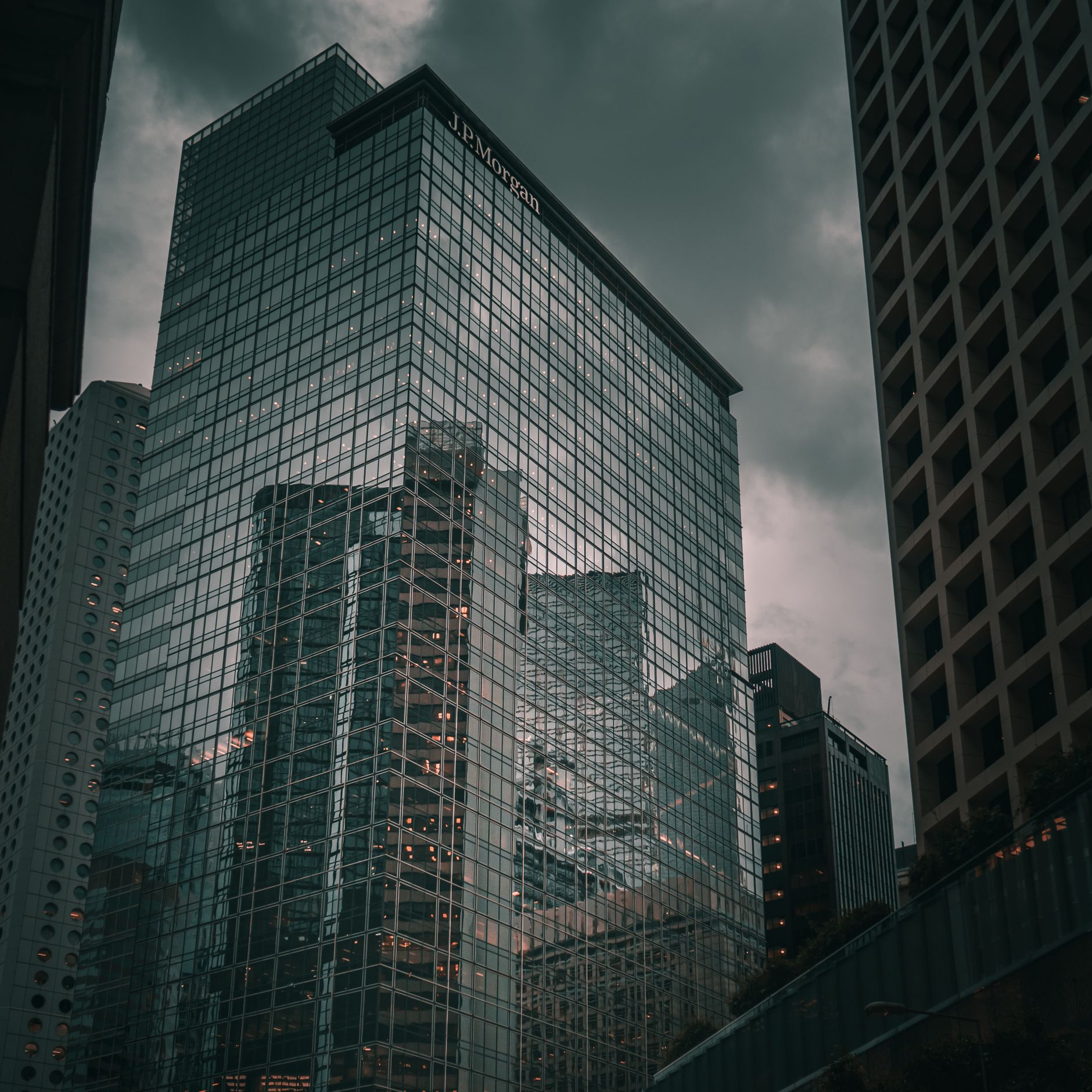 A glass skyscraper in a financial district reflecting the city