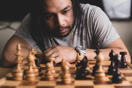 Free A Man in Gray Shirt Playing Chess Stock Photo