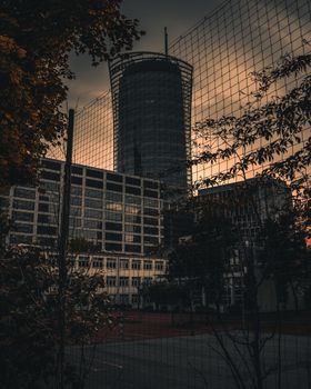 华沙日落时分，前景是带有铁丝网围栏的高层建筑