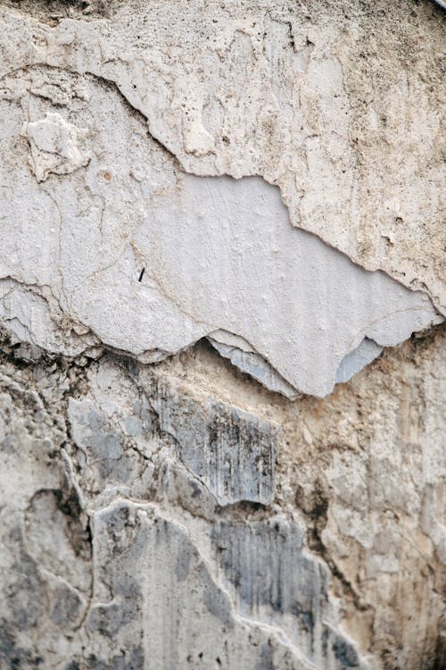Closeup of old shabby concrete wall with cracks and rough texture as abstract background