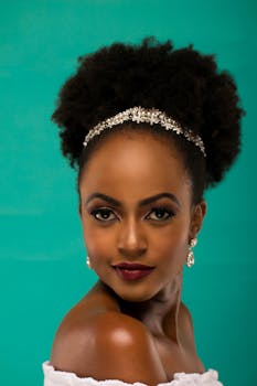 这幅肖像画令人惊叹，描绘了一位留着非洲发型、佩戴优雅珠宝的女子，背景为绿色