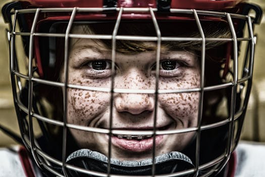 A vibrant close-up of a young ice hockey player smiling confidently with freckles and helmet.