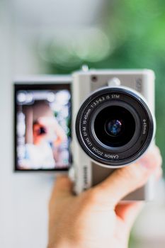 Detailed view of a camera with flip screen showing a blurred selfie. Perfect for tech enthusiasts.