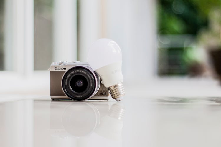 Photo Of Camera Near Light Bulb