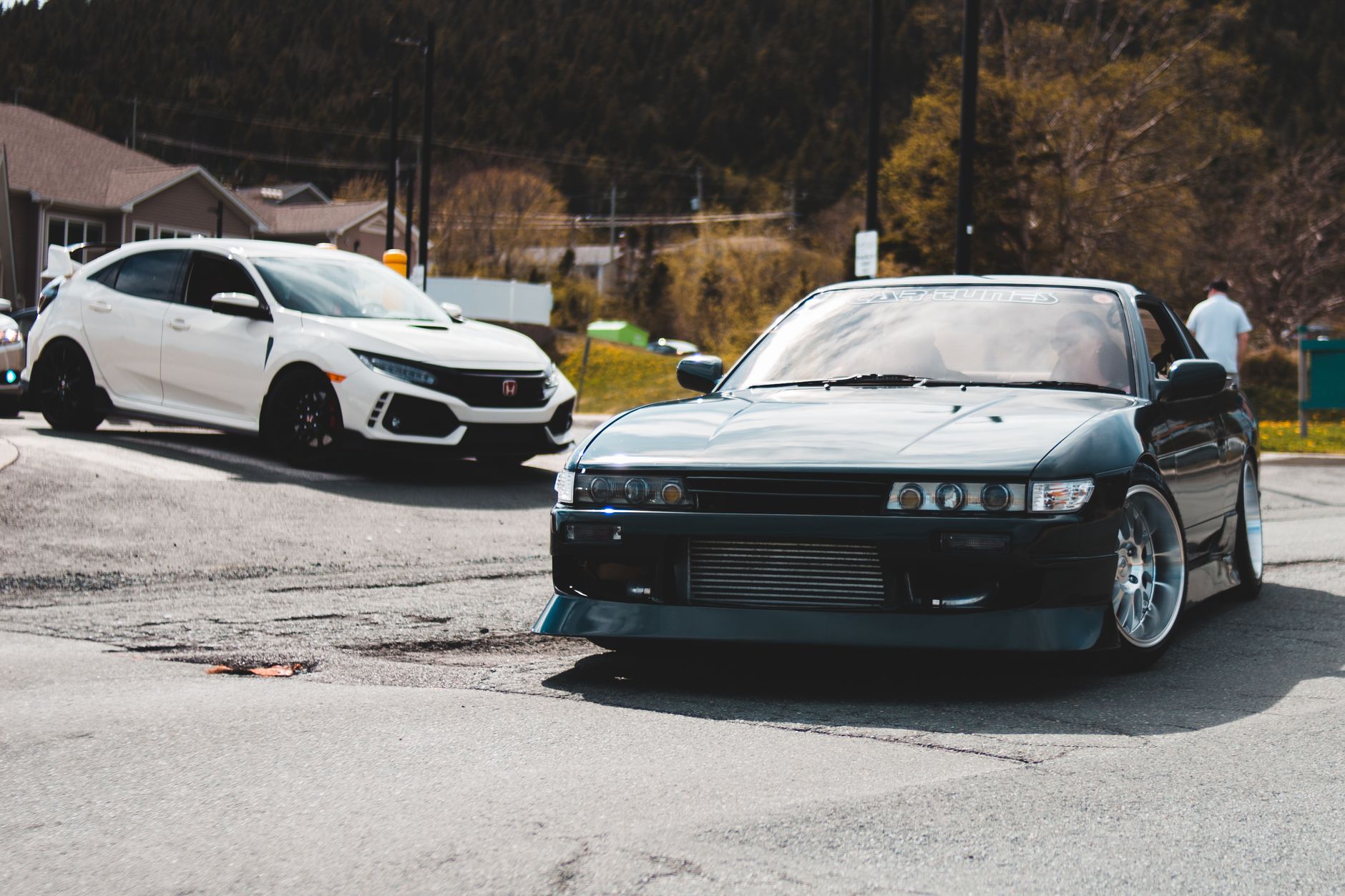 Two stylish cars captured in motion on an urban street, exuding speed and modernity.