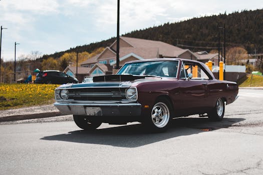 A classic vintage car parked on a street under the sun, showcasing timeless automotive design.