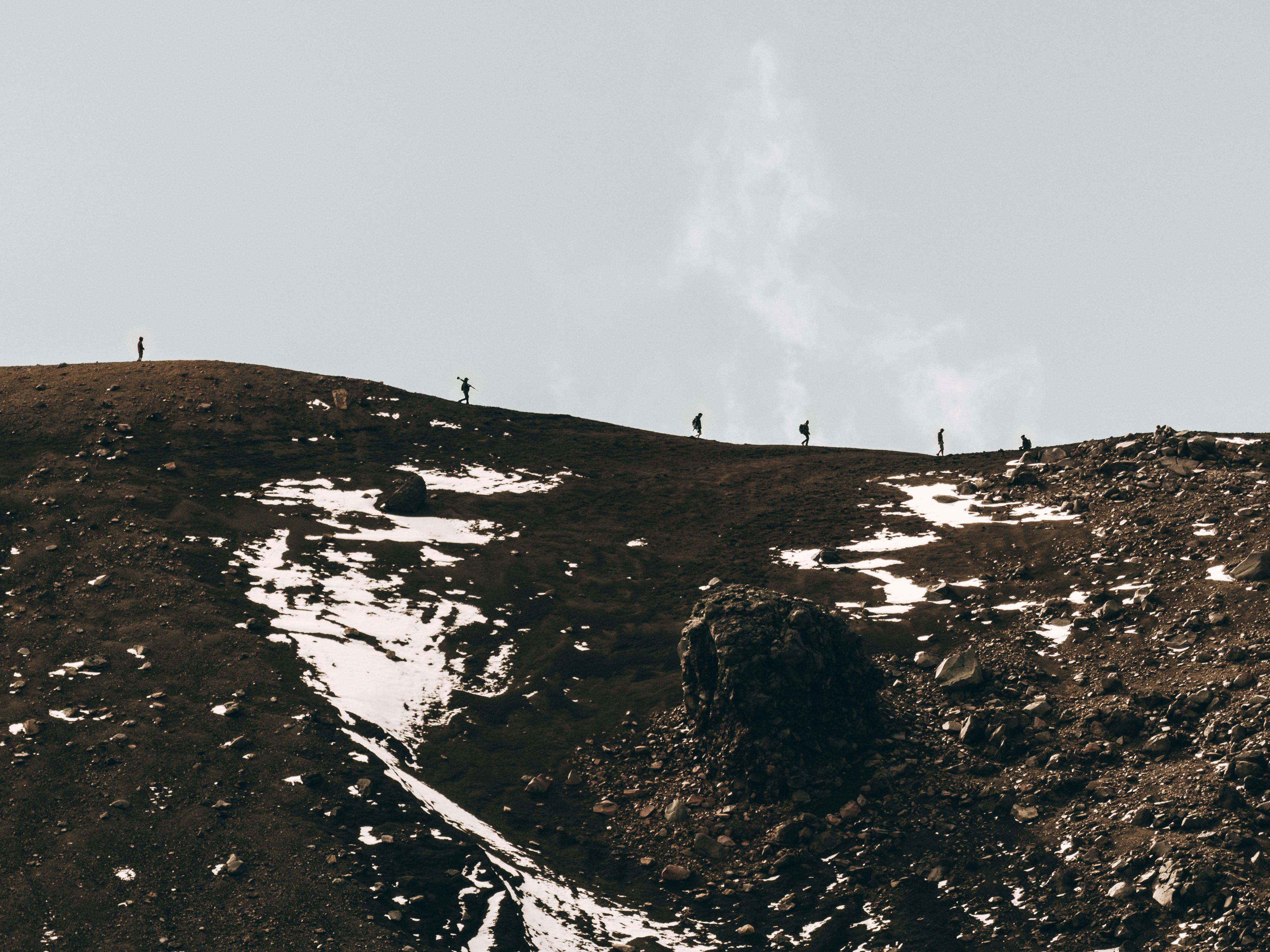 Prescription Goggle Inserts - Group of hikers on a remote snow-covered mountain trail under a cloudy sky.