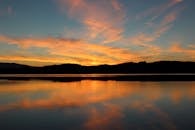 日落倒映在宁静的湖面上，营造出一种宁静的氛围