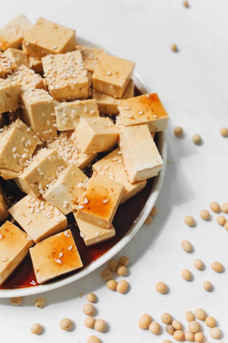 Close-Up Shot Of Sliced Tofu With Sesame Seeds On White Ceramic Plate