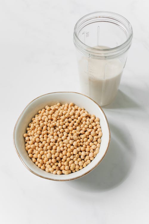 Free Photo of Soybeans on Bowl Near Drinking Glass With Soy Milk Stock Photo