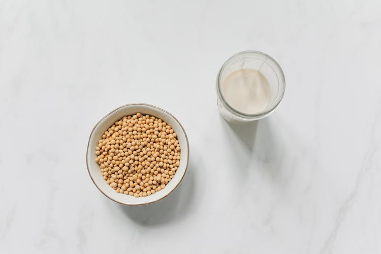 Top View Photo Of Soybeans On Bowl Near Drinking Glass With Soy Milk