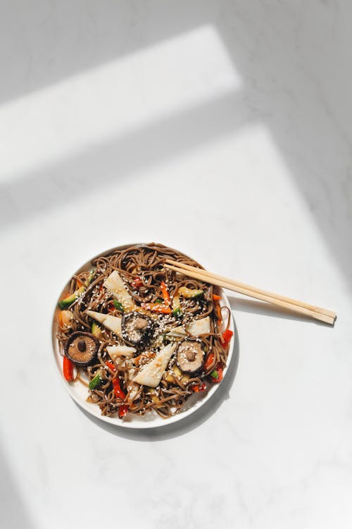 Photo of Noodle Dish and Chopstick on White Ceramic Plate