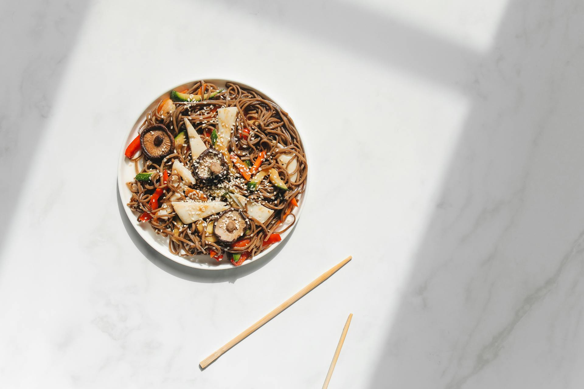 Photo of Noodle Dish on White Ceramic Plate Against White Background