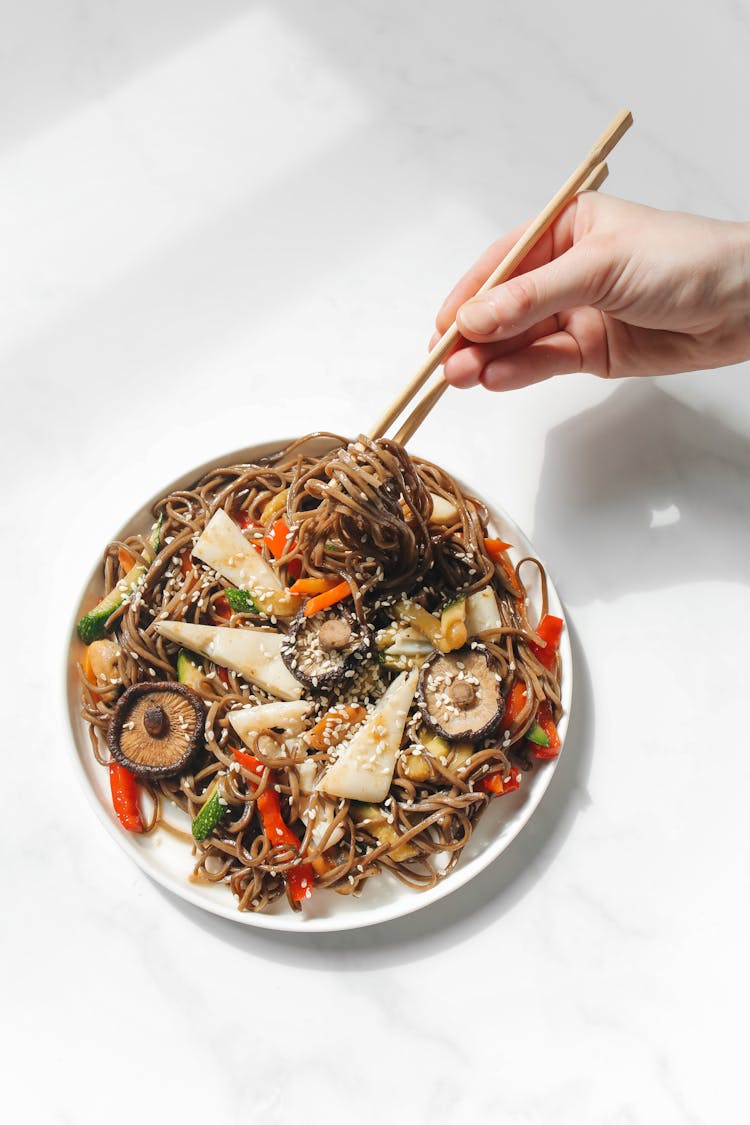 Person's Hand Using Chopstick