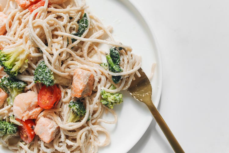 Pasta With Vegetables And Meat On A White Plate