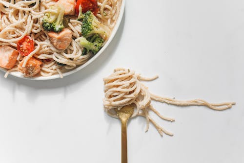 Pasta in a Fork on a White Surface