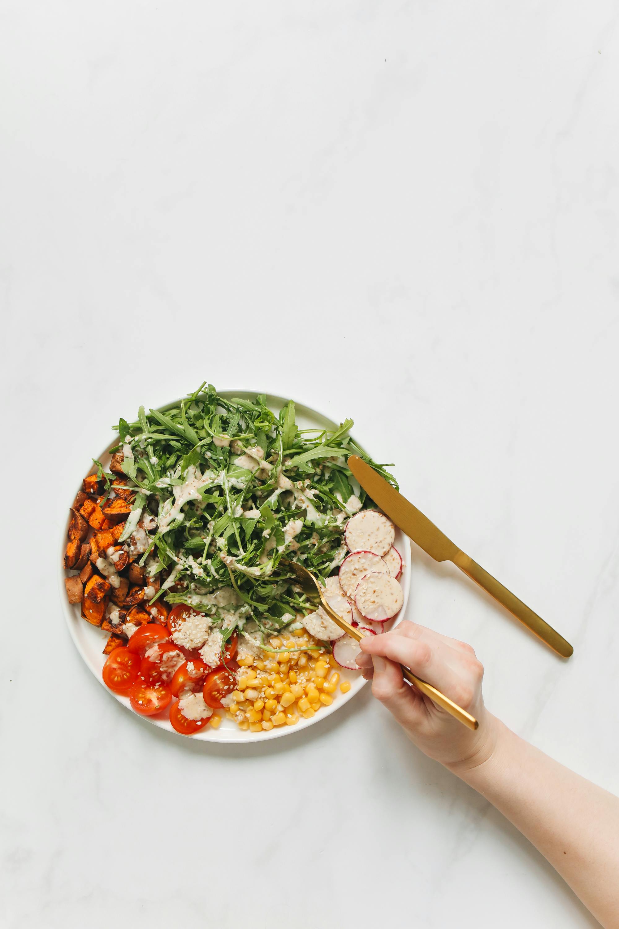 俯视图中，健康芝麻菜沙拉搭配着色彩缤纷的蔬菜，非常适合营养膳食