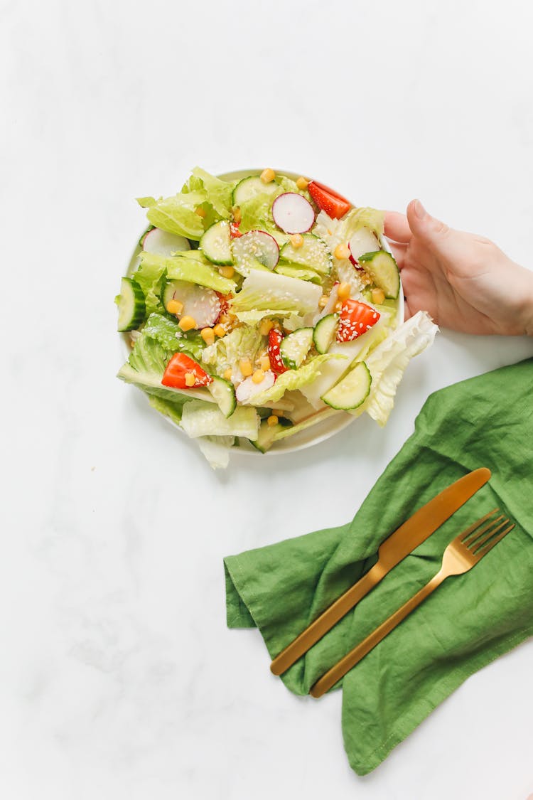 Close Up Of Hand Holding Salad Plate