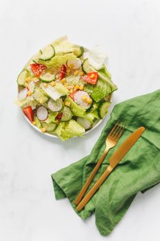 现代金色餐具搭配的新鲜蔬菜沙拉顶视图