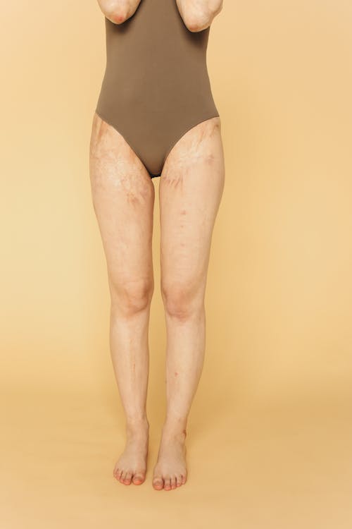 A Woman in Brown Bodysuit Standing Barefooted