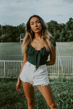一位自信的女人穿着休闲夏装，在公园里摆着姿势
