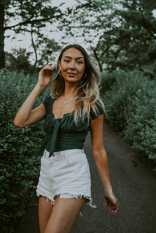 Free Young ethnic woman walking in green park Stock Photo