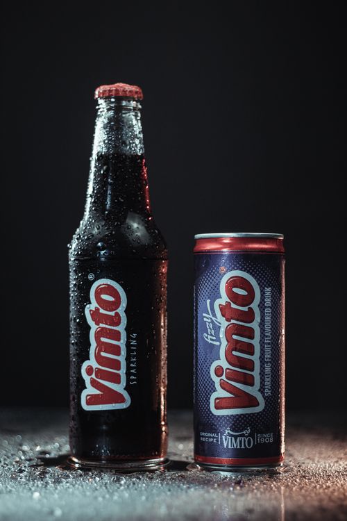 Free A studio shot of Vimto glass bottle and can with condensation, showcasing refreshing appeal. Stock Photo