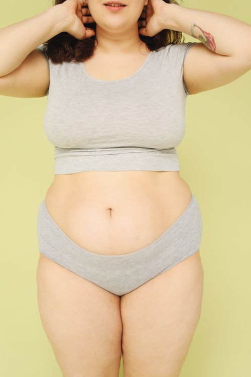 Free Empowering portrait of a plus size woman embracing body positivity in a studio setting. Stock Photo