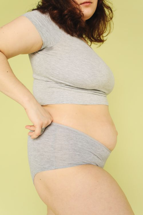 Free Confident plus size woman in underwear promotes body positivity in studio setting. Stock Photo