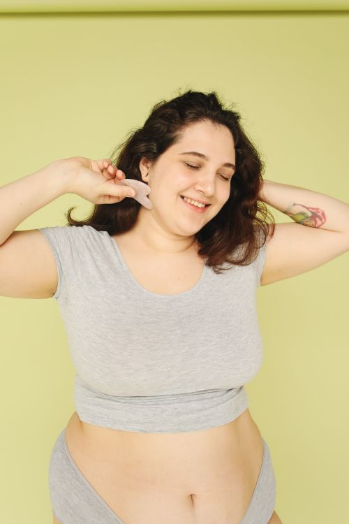 Free Happy plus size woman smiling with closed eyes on a studio shoot with green background. Stock Photo