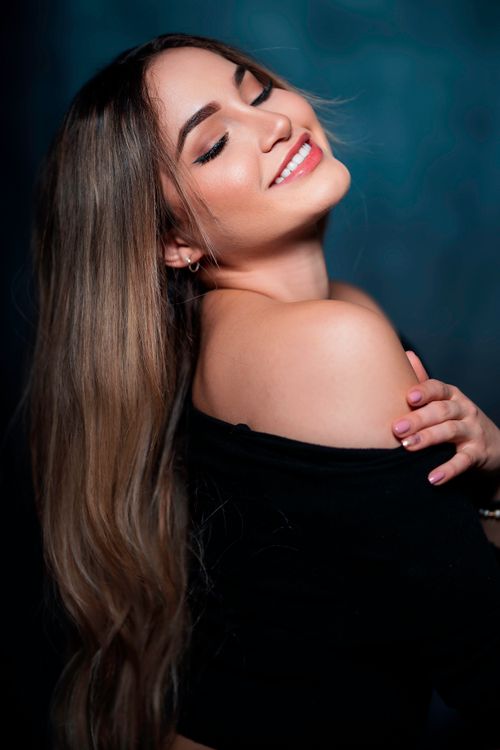 Free Elegant portrait of a woman with closed eyes and a smile, showcasing beauty and fashion in a studio setting. Stock Photo