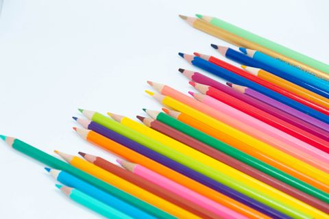 Rainbow of colour pencils on white
