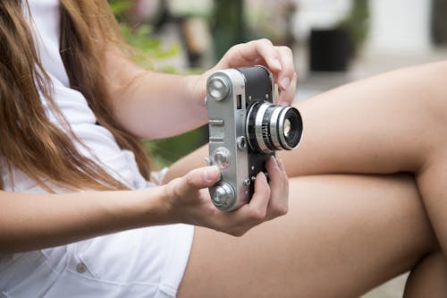 무료 회색과 검은 색 조정 가능한 렌즈 카메라를 들고 여자 스톡 사진